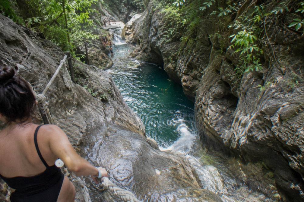 Canyon pool with clear turquoise water between steep rock walls