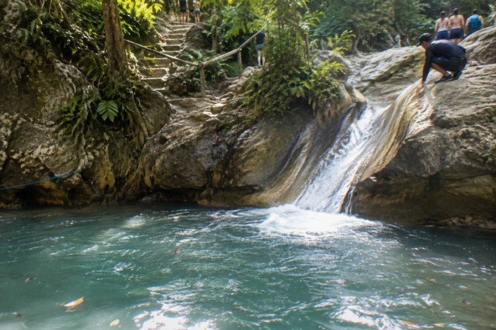 Guide demonstrating a slide position at the top of a smooth rock chute into a deep pool