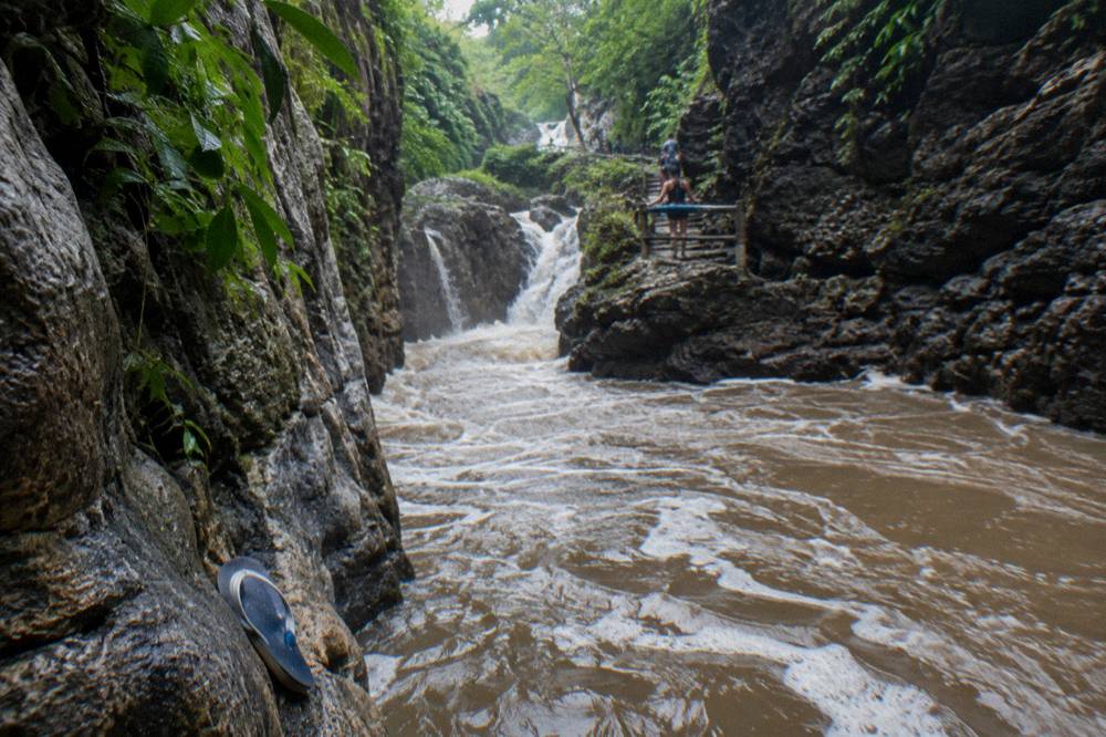 Canyon river running brown and high between rock walls after heavy rain