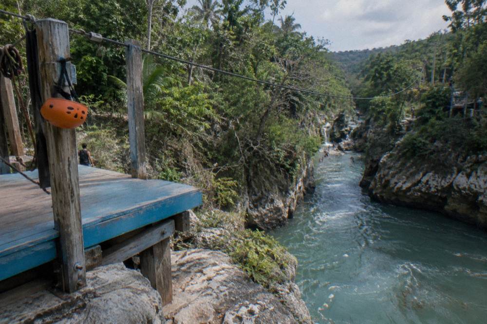 Steel zipline cable crossing above tropical forest canopy